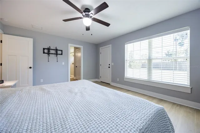 a view of a hallway with wooden floor and a bathroom