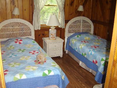 150 Great Pond Road Eastham, MA 02642 - Photo 8 of 14 a bedroom with a bed a dresser with wooden floor