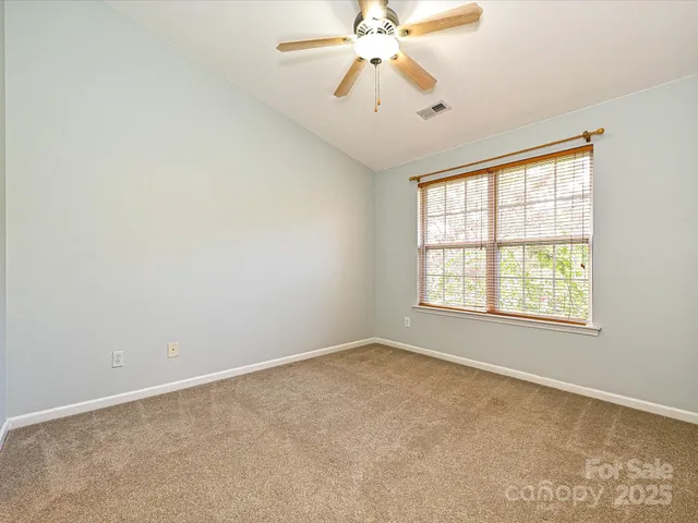 an empty room with a window and a fan