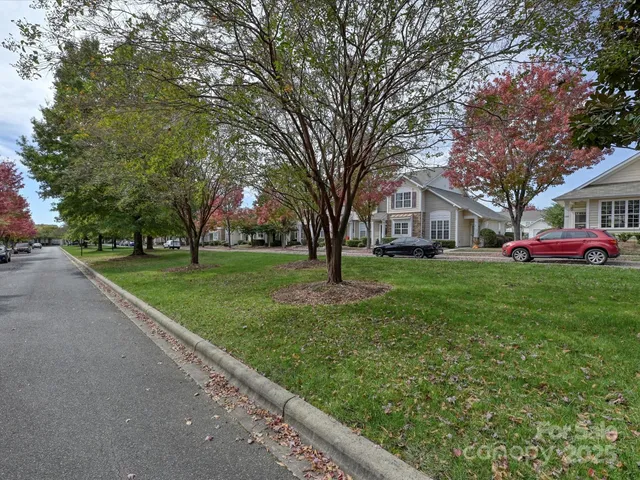 a front view of a house with a garden and trees