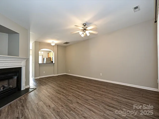 a view of empty room with wooden floor and fireplace
