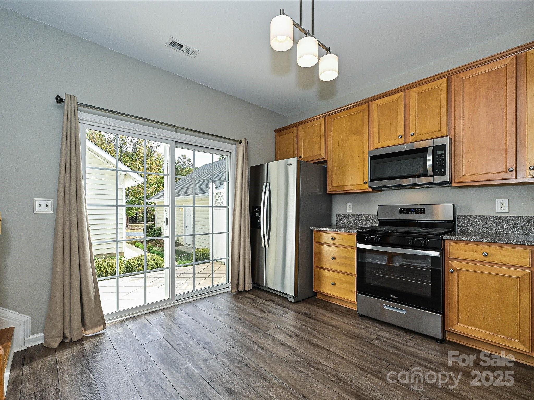 1115 Drummond Lane Matthews, NC 28104 - Photo 10 of 24 a kitchen with stainless steel appliances granite countertop a stove top oven a refrigerator a kitchen island a sink and a microwave
