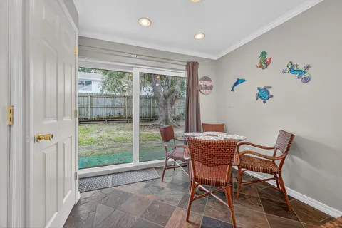 a dining room with furniture and a floor to ceiling window