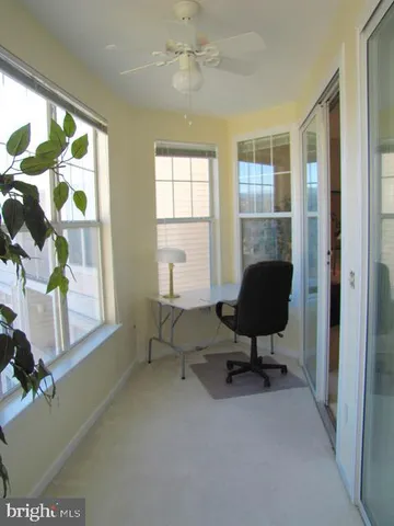 a view of a workspace with furniture and a window