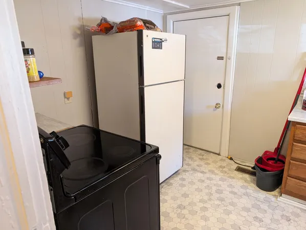a kitchen with a refrigerator and a stove