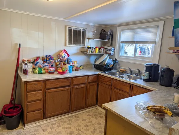 a kitchen with granite countertop lots of clutter and stainless steel appliances