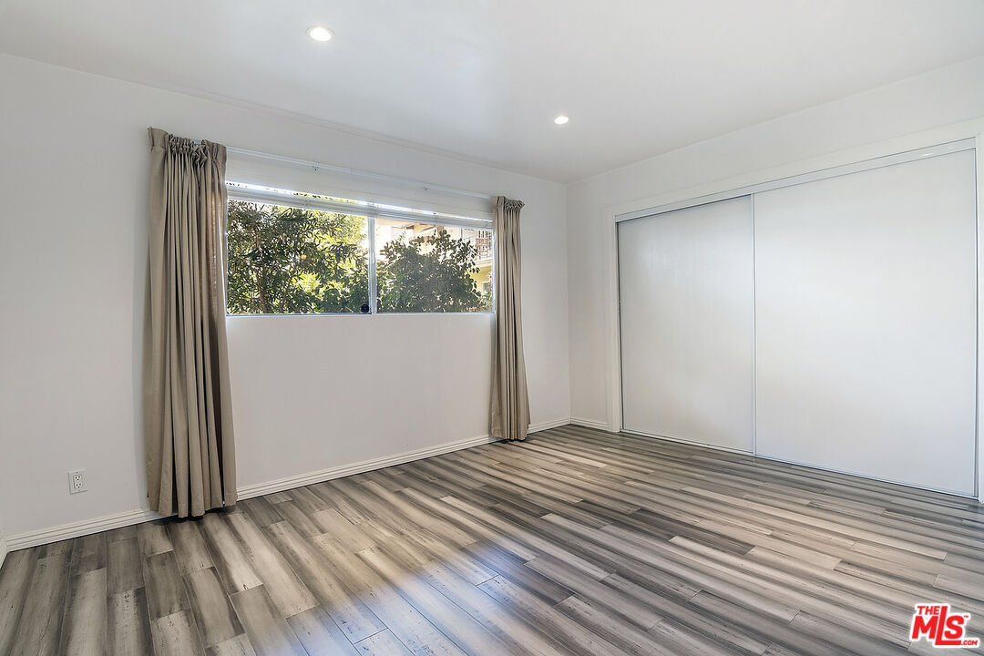 923 17th Street, Unit 3 Santa Monica, CA 90403 - Photo 13 of 22 a view of an empty room with wooden floor and a window