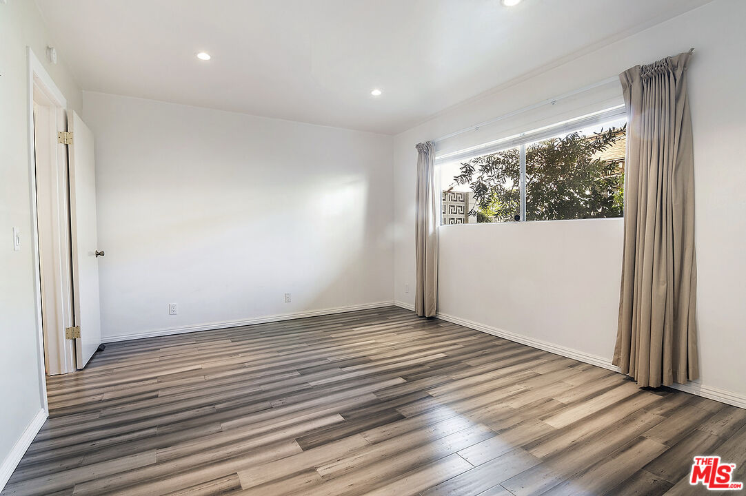 923 17th Street, Unit 3 Santa Monica, CA 90403 - Photo 15 of 22 a view of an empty room with wooden floor and a window