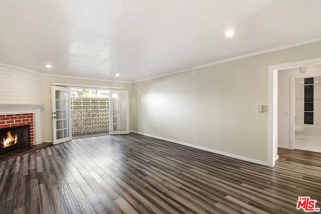 923 17th Street, Unit 3 Santa Monica, CA 90403 - Photo 7 of 22 an empty room with wooden floor fireplace and windows