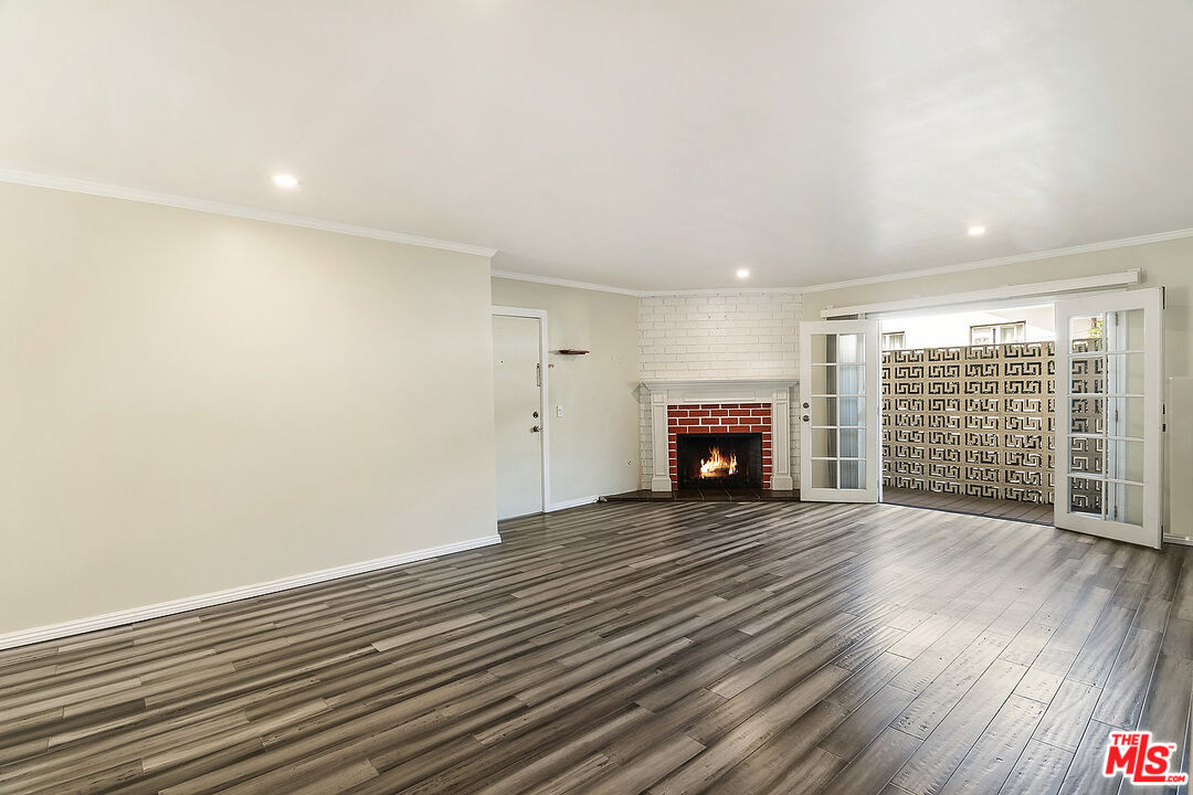923 17th Street, Unit 3 Santa Monica, CA 90403 - Photo 8 of 22 a view of an empty room with wooden floor fireplace and a window