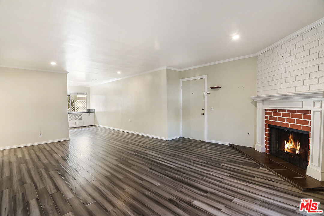 923 17th Street, Unit 3 Santa Monica, CA 90403 - Photo 9 of 22 a view of an empty room with wooden floor fireplace and a window