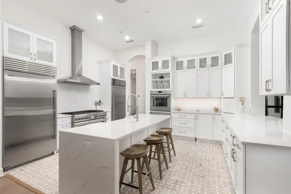 a kitchen with stainless steel appliances kitchen island granite countertop a stove and cabinets