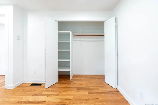a view of an empty room with wooden floor