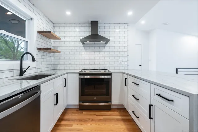 a kitchen with granite countertop white cabinets and stainless steel appliances