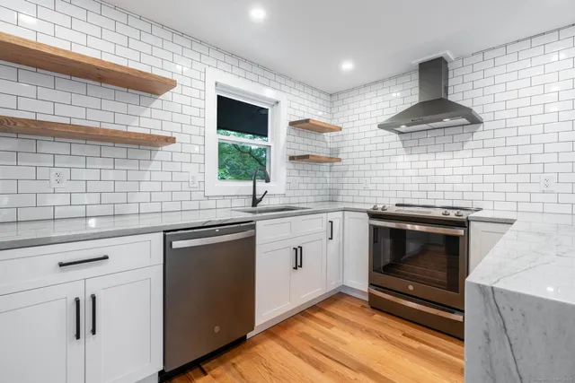 a kitchen with stainless steel appliances a stove sink and microwave