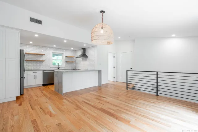a view of kitchen with granite countertop cabinets and refrigerator