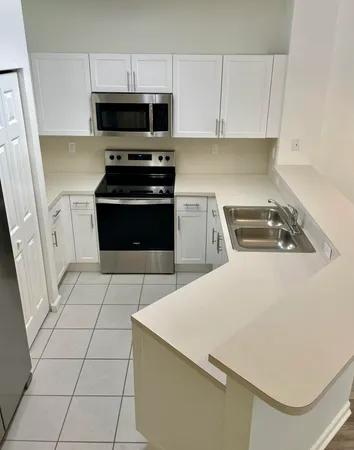 a kitchen with a sink a stove and cabinets