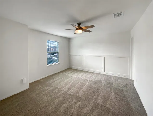 an empty room with a window and a ceiling fan