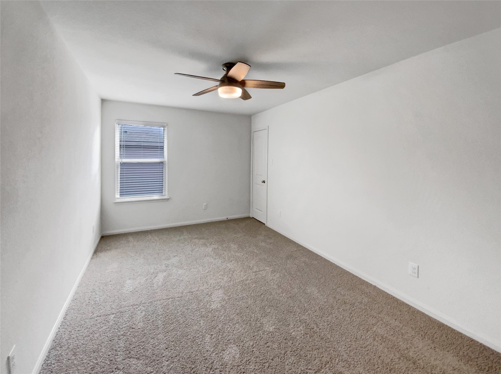 138 Niven Path, Unit 26E Jarrell, TX 76537 - Photo 18 of 21 an empty room with a window and a ceiling fan