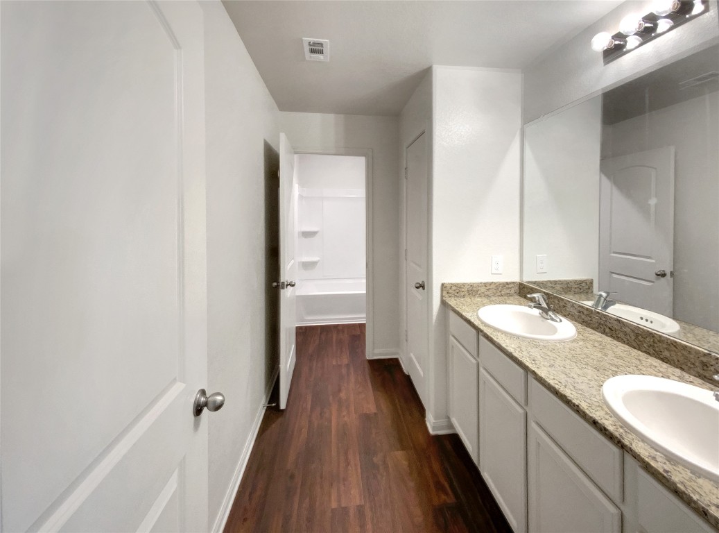 138 Niven Path, Unit 26E Jarrell, TX 76537 - Photo 19 of 21 a spacious bathroom with a granite countertop sink and a mirror