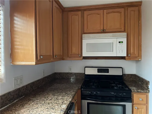 a kitchen with granite countertop cabinets stove and oven