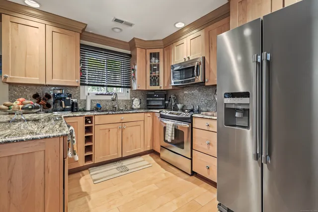 a kitchen with stainless steel appliances granite countertop a refrigerator sink and cabinets