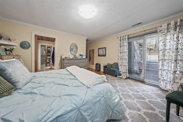 a bedroom with a bed and a dresser next to a window