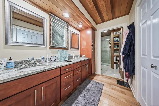 a en suite bathroom with a granite countertop sink and a mirror
