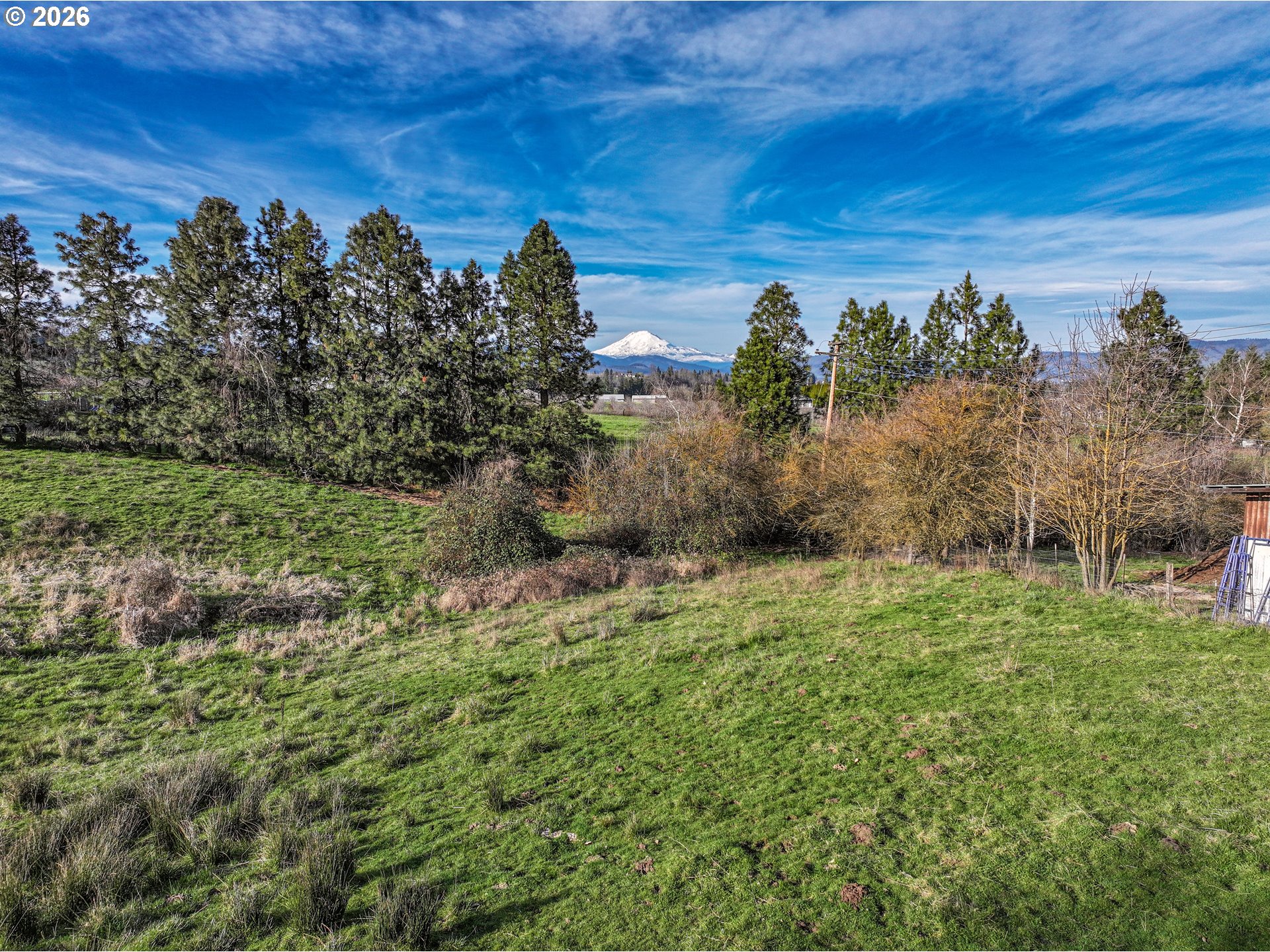2739 Wyeast Road Hood River, OR 97031 - Photo 5 of 28 a view of a field with an ocean and trees in the background