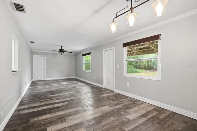 an empty room with fan and windows