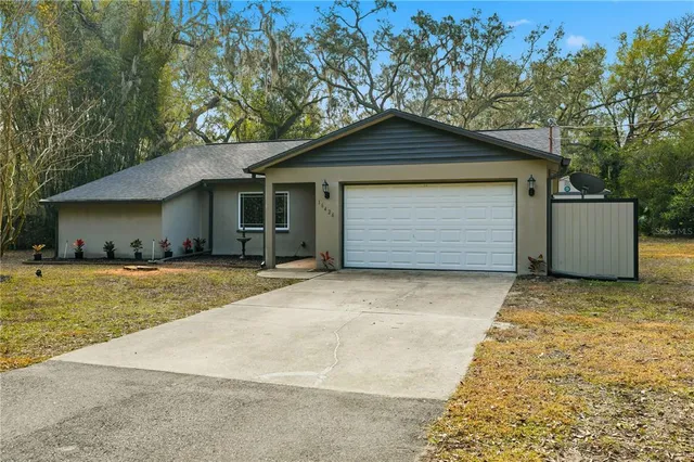 a front view of house with yard and trees in the background