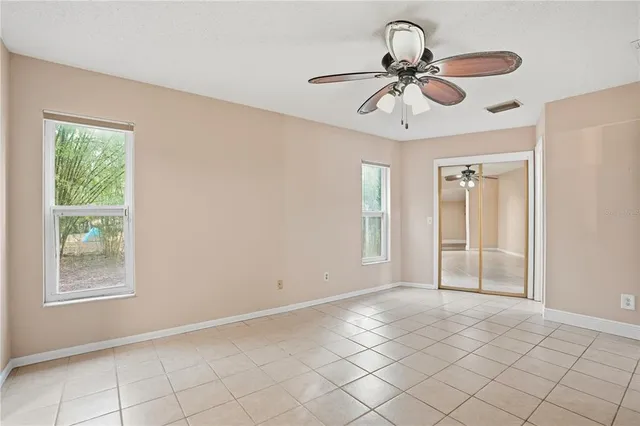 an empty room with closet and a chandelier fan