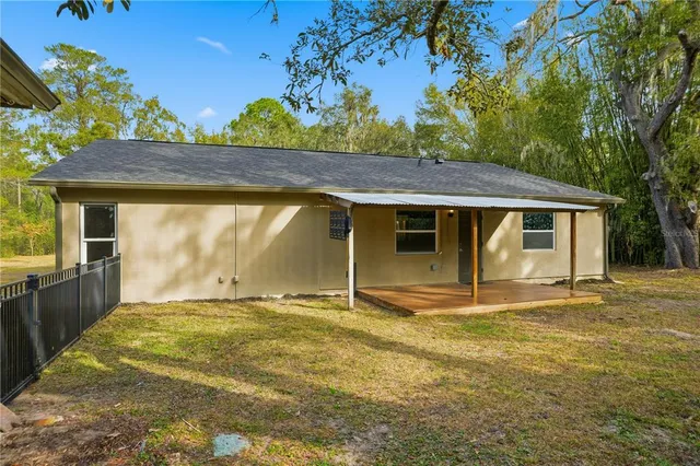 an aerial view of residential house with outdoor space and trees all around