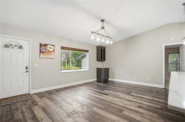 a view of a room that has a window and wooden floor