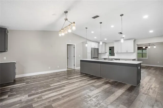 a kitchen with stainless steel appliances white cabinets and a refrigerator