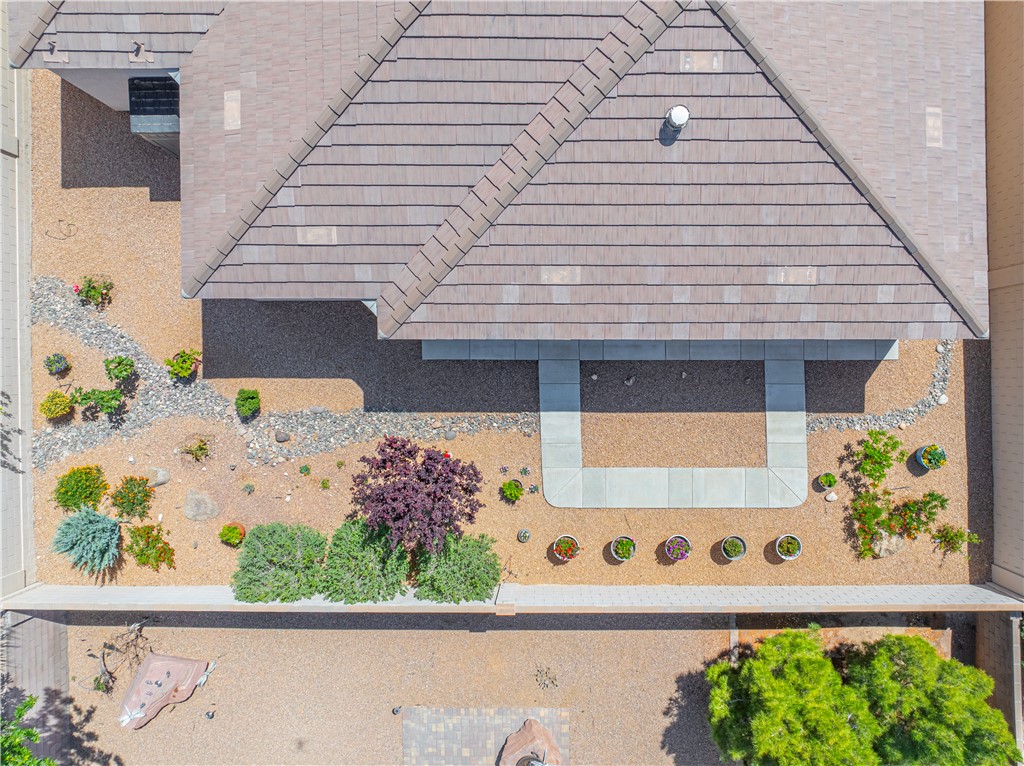 3315 Rainbow Mine Road Kingman, AZ 86401 - Photo 44 of 54 The property features a well-maintained roof with neutral-toned shingles, a pathway composed of light-colored pavers, and landscaping with a variety of plantings and gravel accents