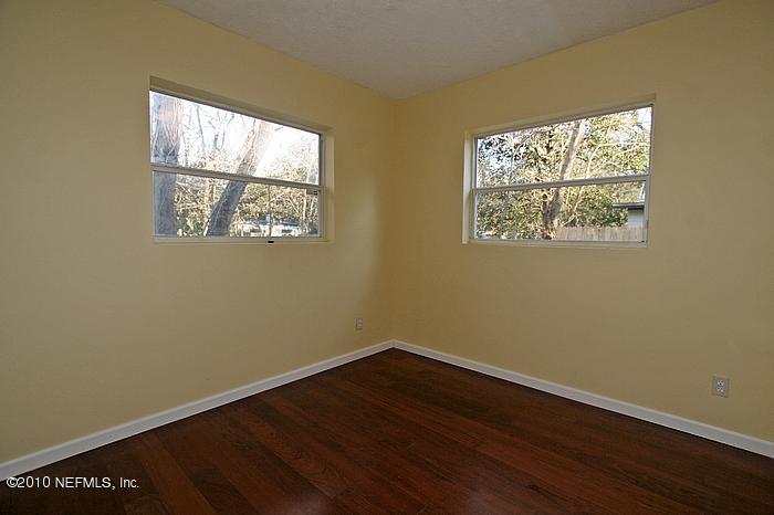 1405 Griflet Road Jacksonville, FL 32211 - Photo 7 of 13 an empty room with wooden floor and windows