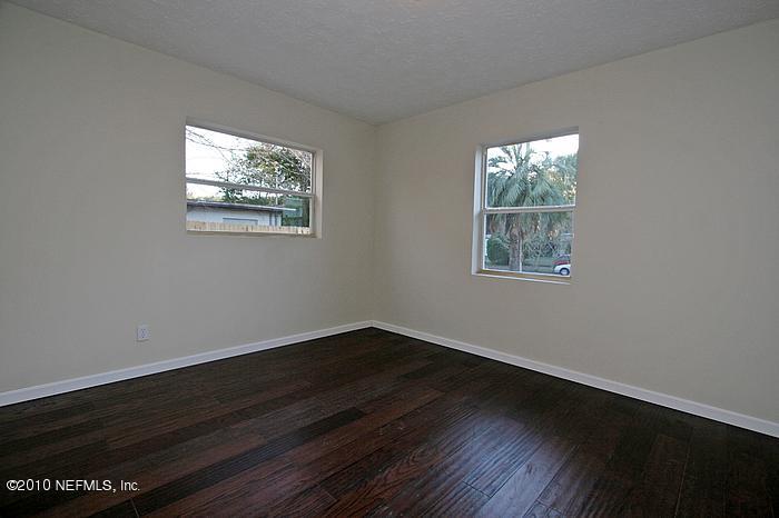 1405 Griflet Road Jacksonville, FL 32211 - Photo 8 of 13 a view of an empty room with wooden floor and a window