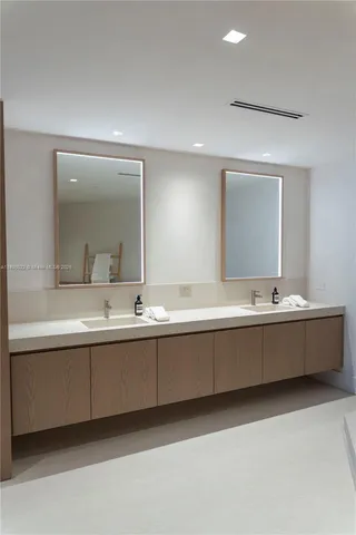 a bathroom with a double vanity sink mirror and toilet