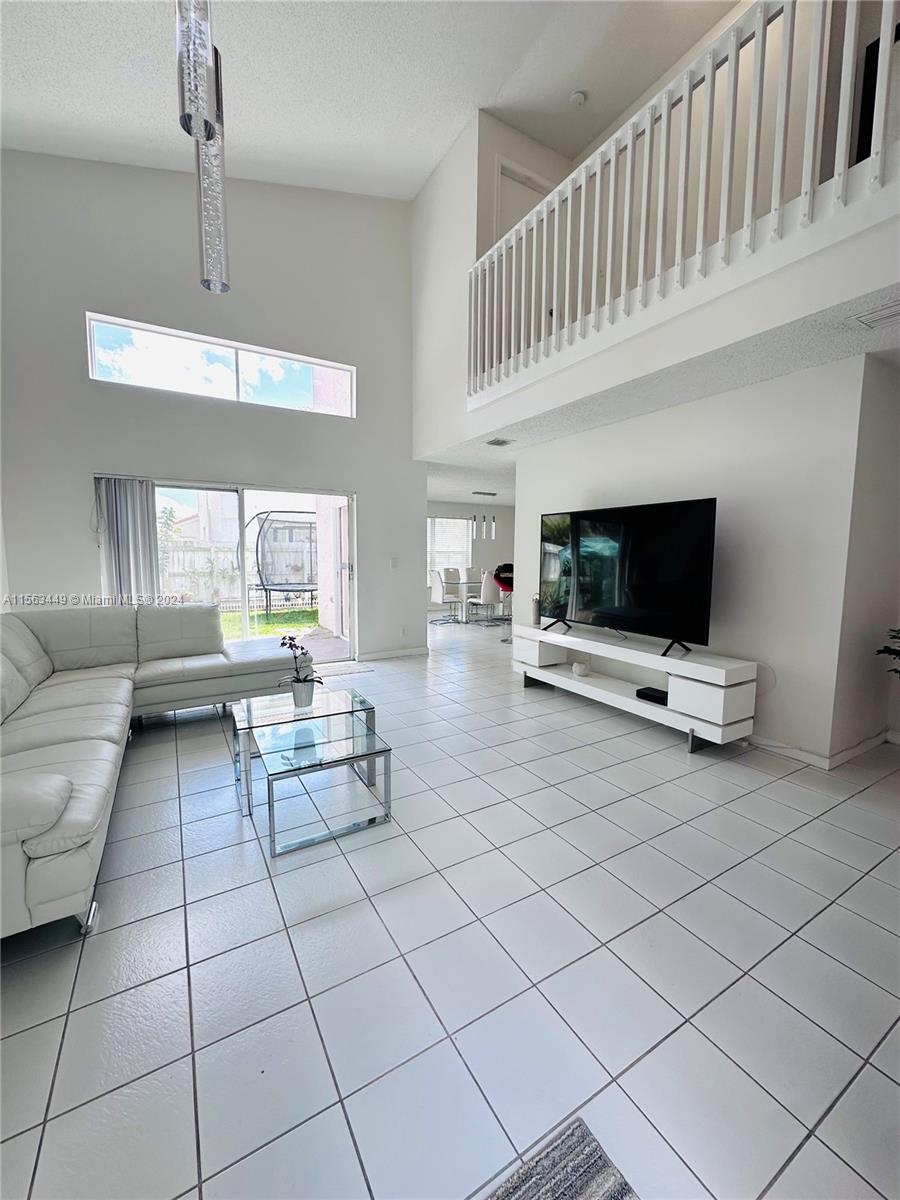 17456 Southwest 20th Street Miramar, FL 33029 - Photo 6 of 34 a living room with furniture and a flat screen tv