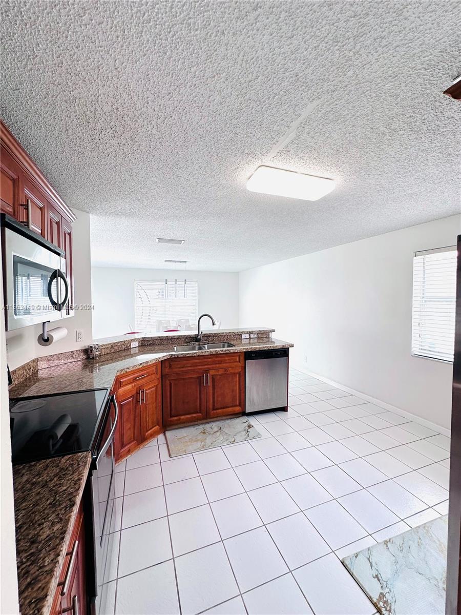 17456 Southwest 20th Street Miramar, FL 33029 - Photo 10 of 34 a kitchen with stainless steel appliances granite countertop a sink and cabinets