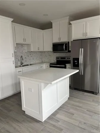 a kitchen with stainless steel appliances white cabinets and a refrigerator