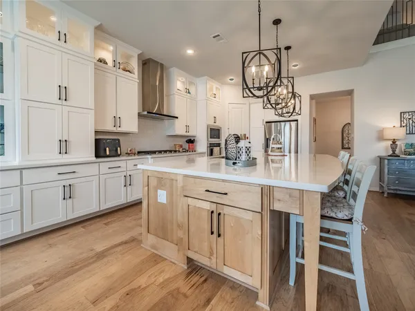 a kitchen with stainless steel appliances granite countertop a sink a stove top oven a counter space and cabinets