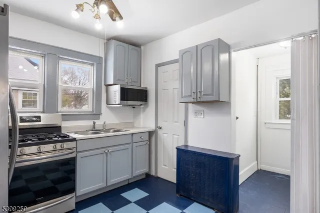 a kitchen with stainless steel appliances a stove sink and microwave