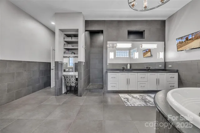 a spacious bathroom with a granite countertop sink and a mirror