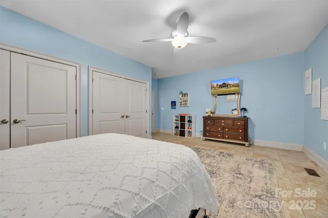 a spacious bedroom with a bed and a chandelier