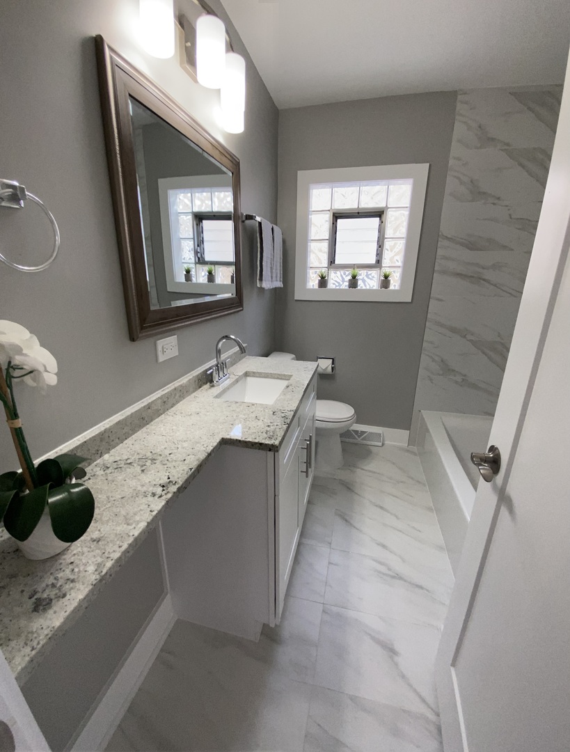 6531 West 64th Street Chicago, IL 60638 - Photo 6 of 19 a bathroom with a granite countertop sink a mirror and shower