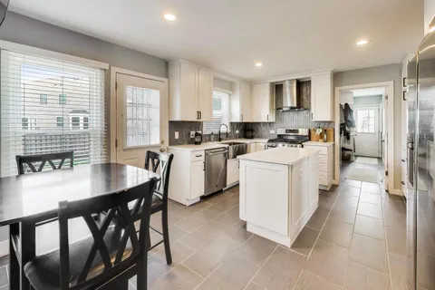 a kitchen with a table chairs stove and cabinets