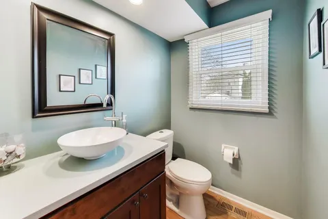 a bathroom with a sink a toilet and mirror