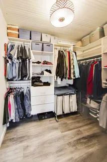 a view of walk in closet with clothes and shoes